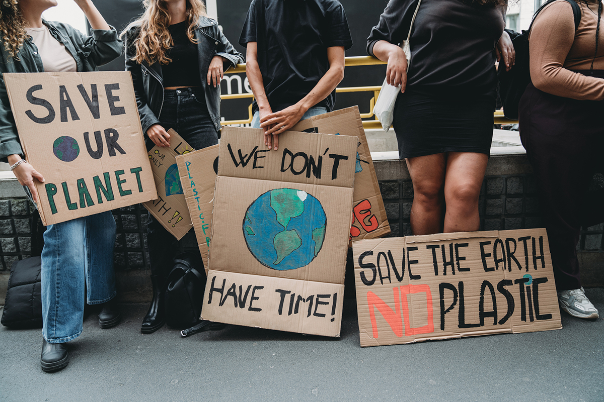 People are holding banner signs while they are going to a demonstration against climate change. Protest against global warming. Climate change protest concept.